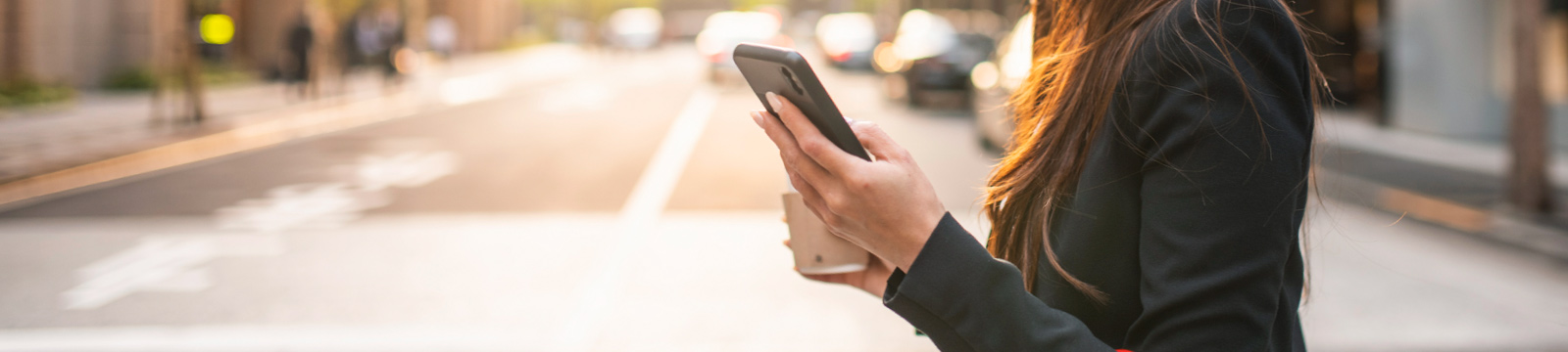 Woman using mobile phone while walking downtown